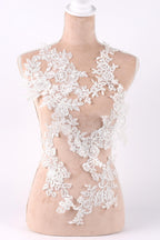 A mannequin wearing a dress with a lace bodice and floral lace overlay.