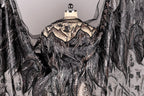 a black and silver dress with intricate beading and embroidery details, including a sheer back and flowing sleeves.