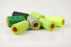 a collection of green and yellow thread spools arranged on a white background.