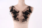 A mannequin with a black lace overlay on its chest area, featuring intricate floral designs.