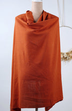 a mannequin wearing a large orange scarf.
