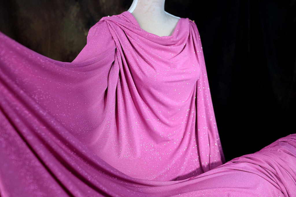 a mannequin wearing a pink draped dress