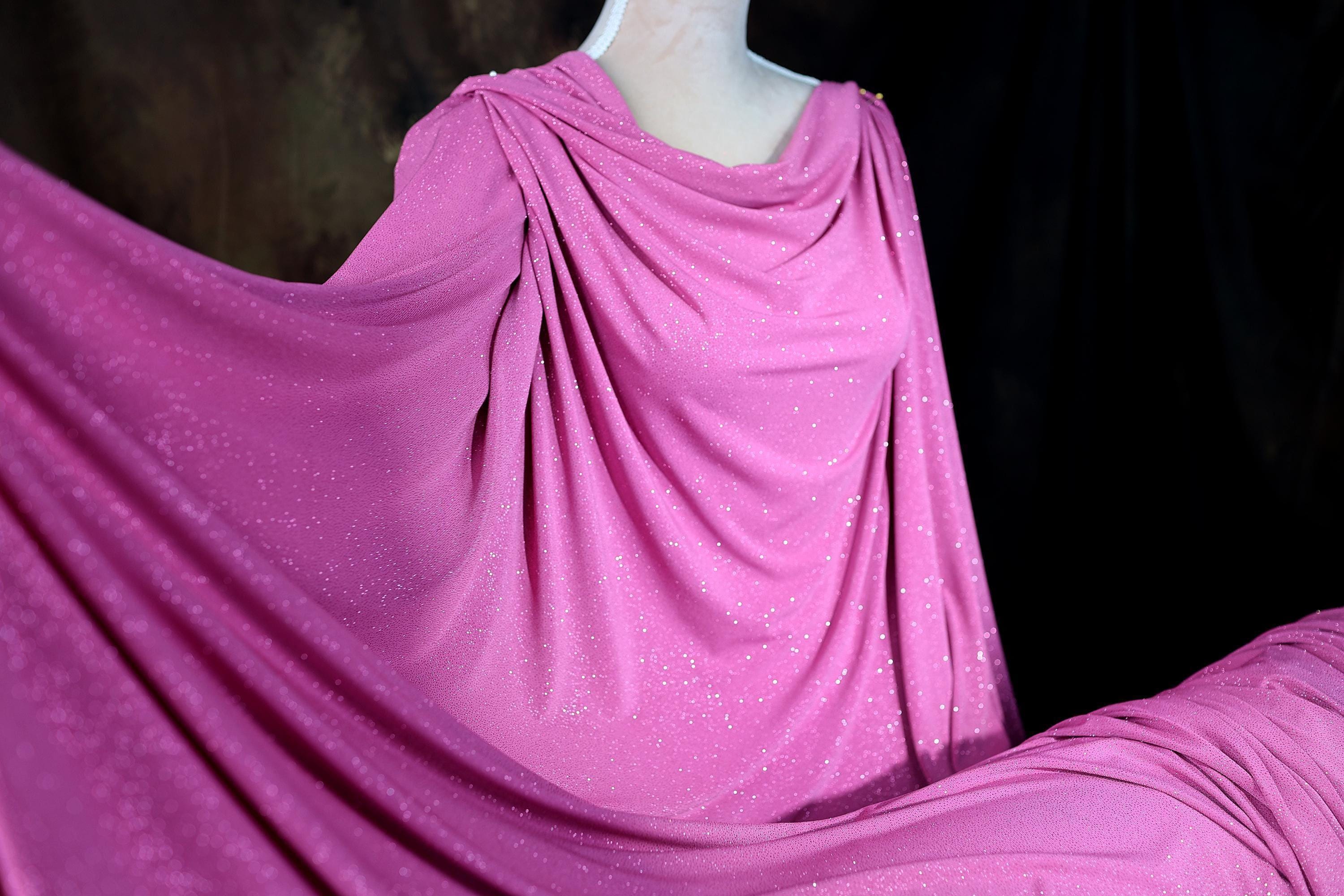 a mannequin wearing a pink draped dress