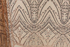 a close-up view of a fabric with a repeating pattern of diamond shapes and small dots in shades of brown and beige. The pattern is intricate and visually striking, with the diamonds and dots creating a sense of depth and texture.