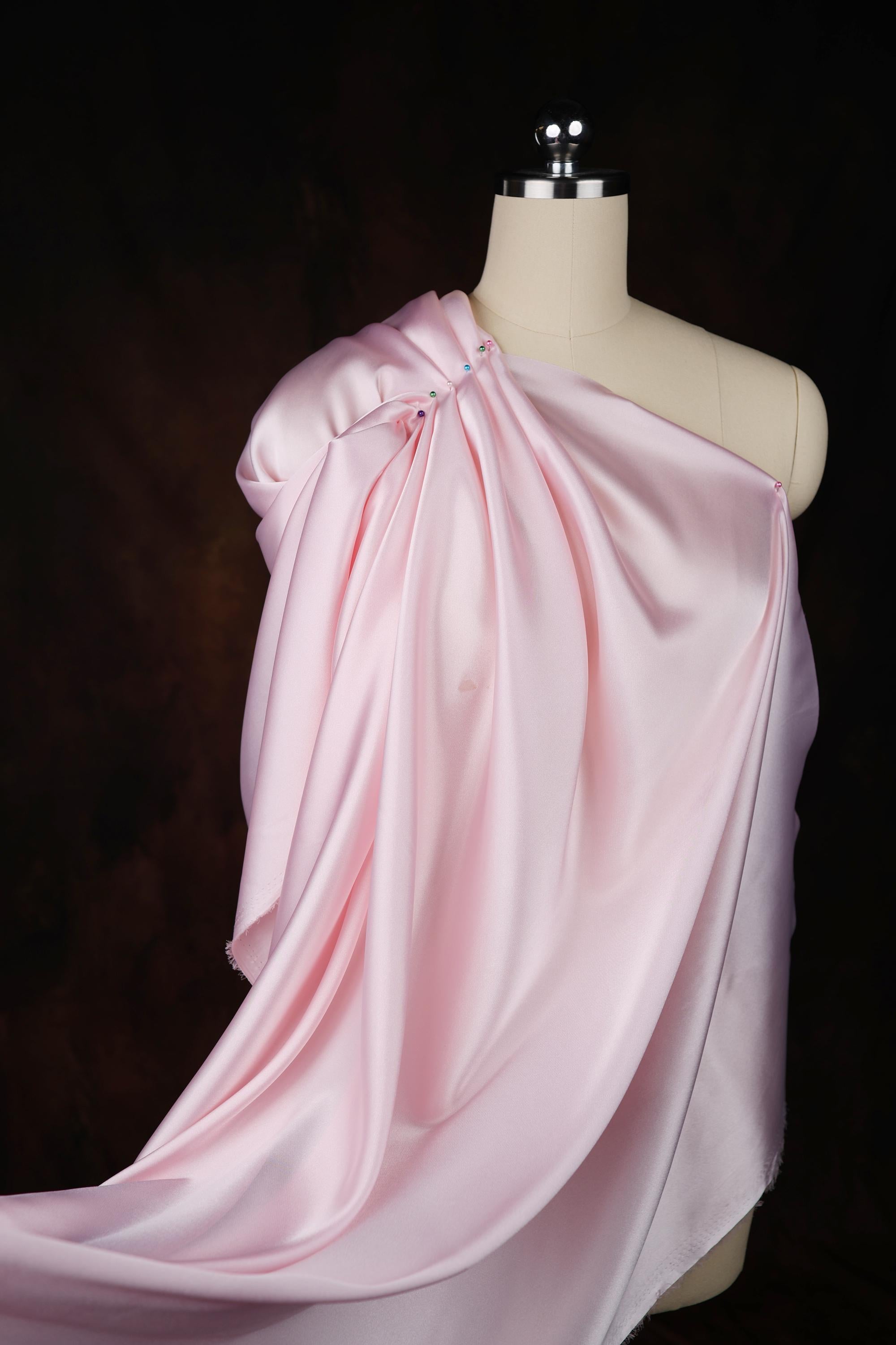 a mannequin wearing a pink draped dress