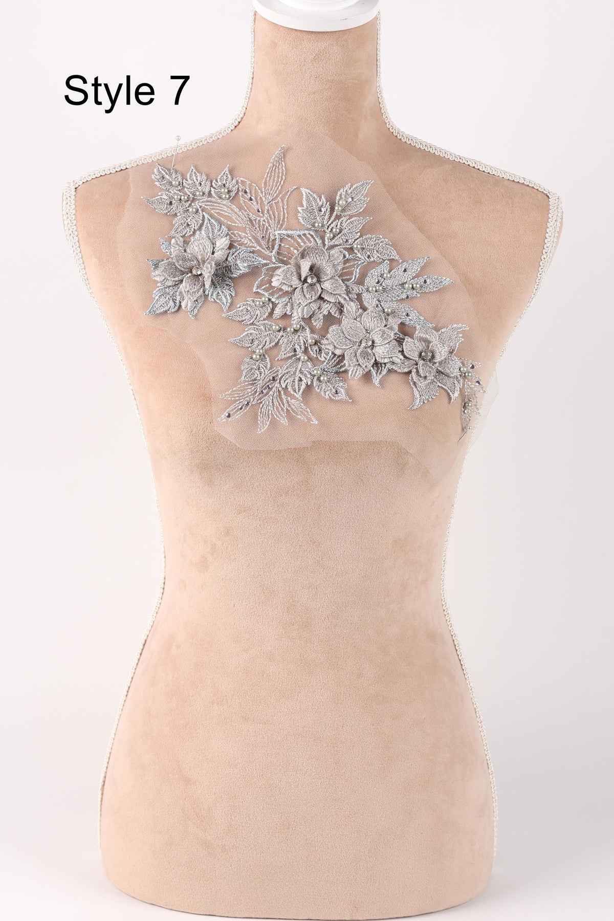 A mannequin with a decorative floral lace piece on its back.