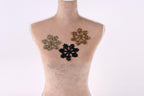 A mannequin with three decorative snowflake-shaped embellishments on its bust.
