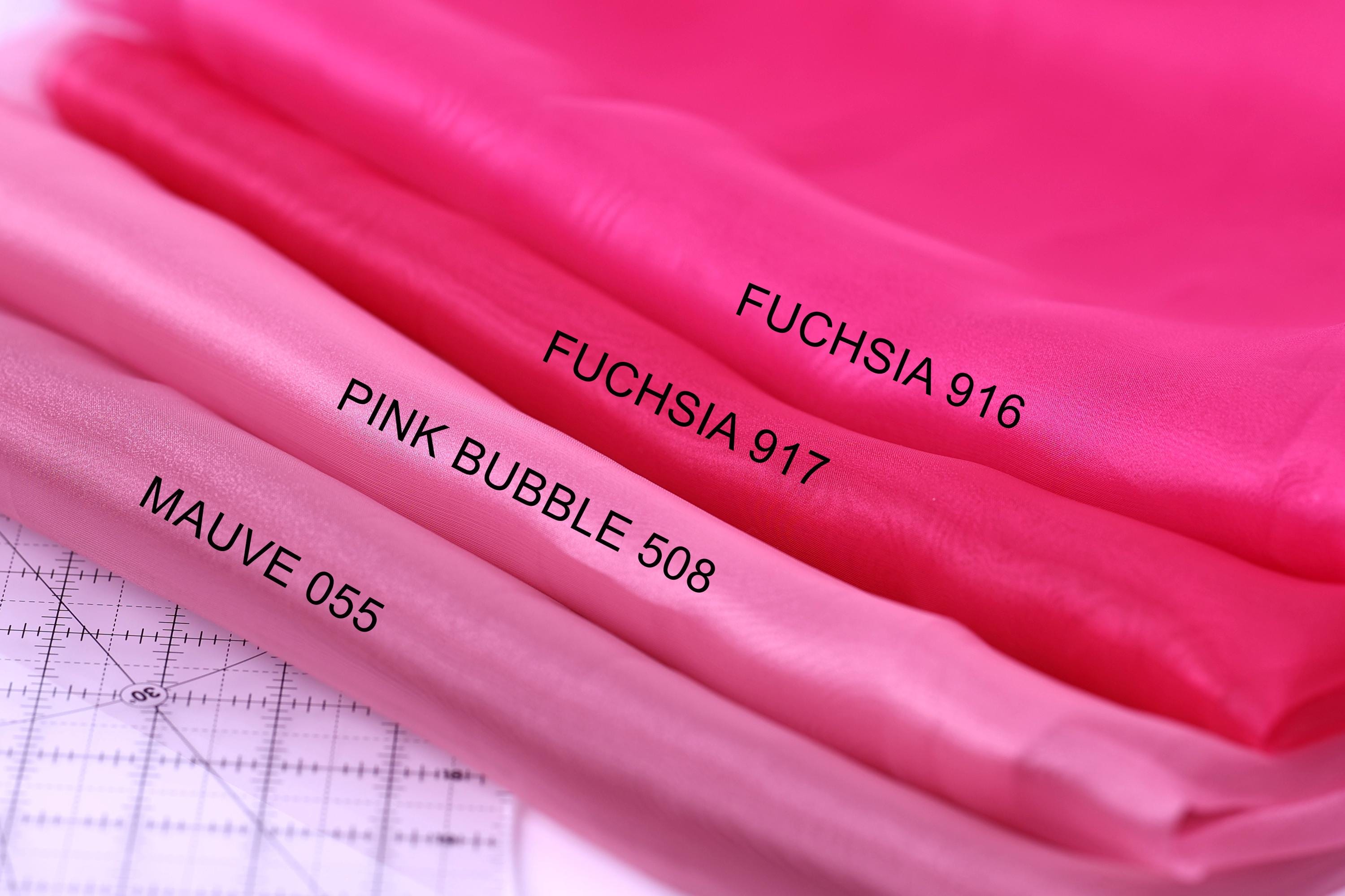 a close-up view of three different shades of pink fabric, with each shade labeled with a number and a name.