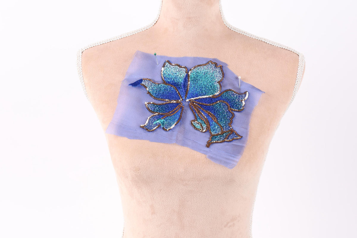 a mannequin torso with a piece of fabric attached to it, featuring a blue and green floral design.