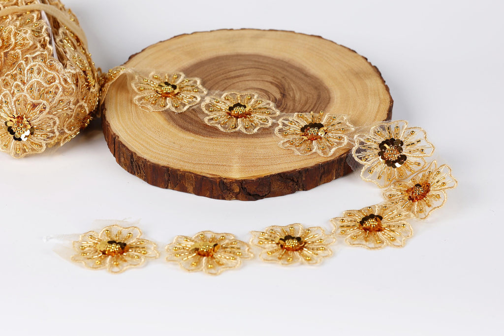 a collection of gold-colored, intricately designed flowers arranged on a wooden surface.