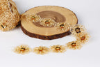 a collection of gold-colored, intricately designed flowers arranged on a wooden surface.