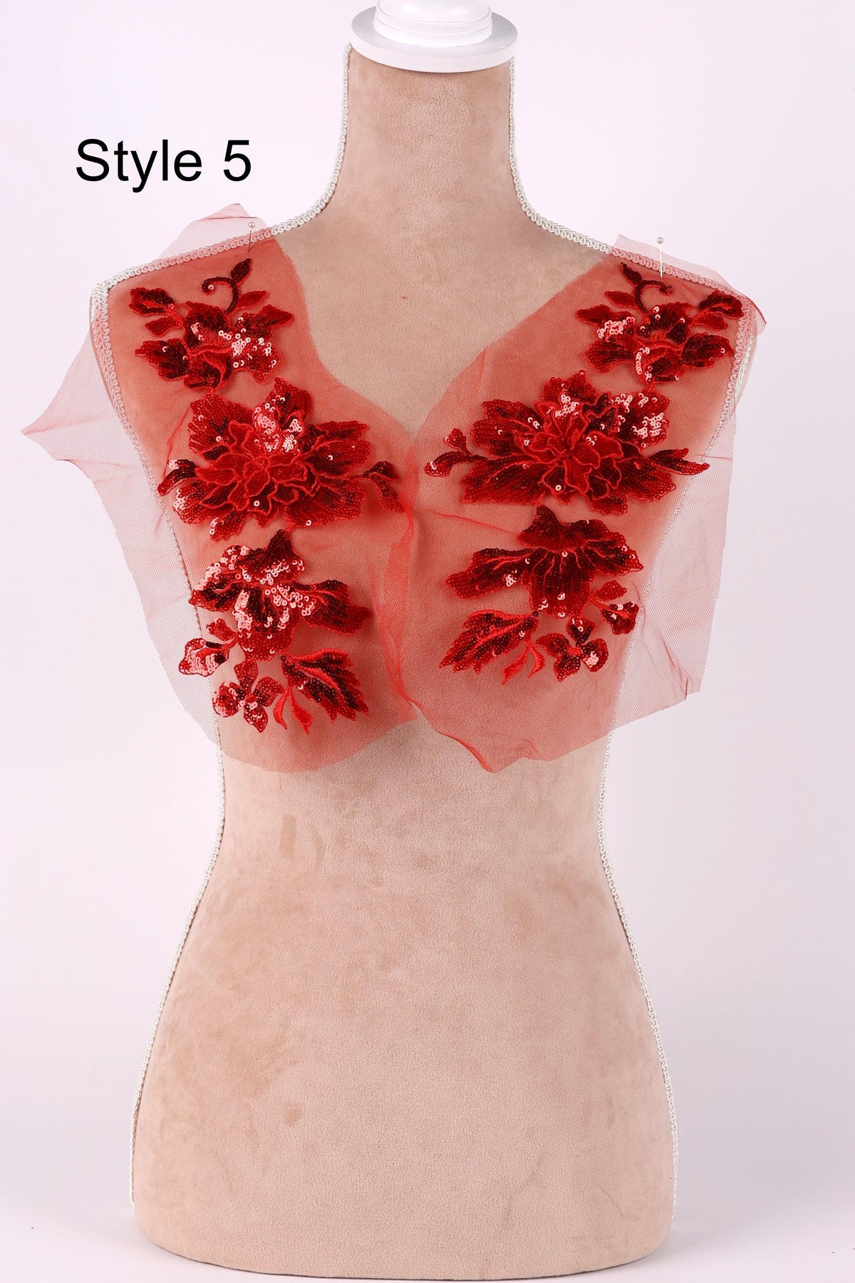 A mannequin with red floral embroidered patches on its shoulders, displayed against a white background.