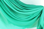 a close-up view of a turquoise fabric, with its folds and creases creating a textured and layered appearance.