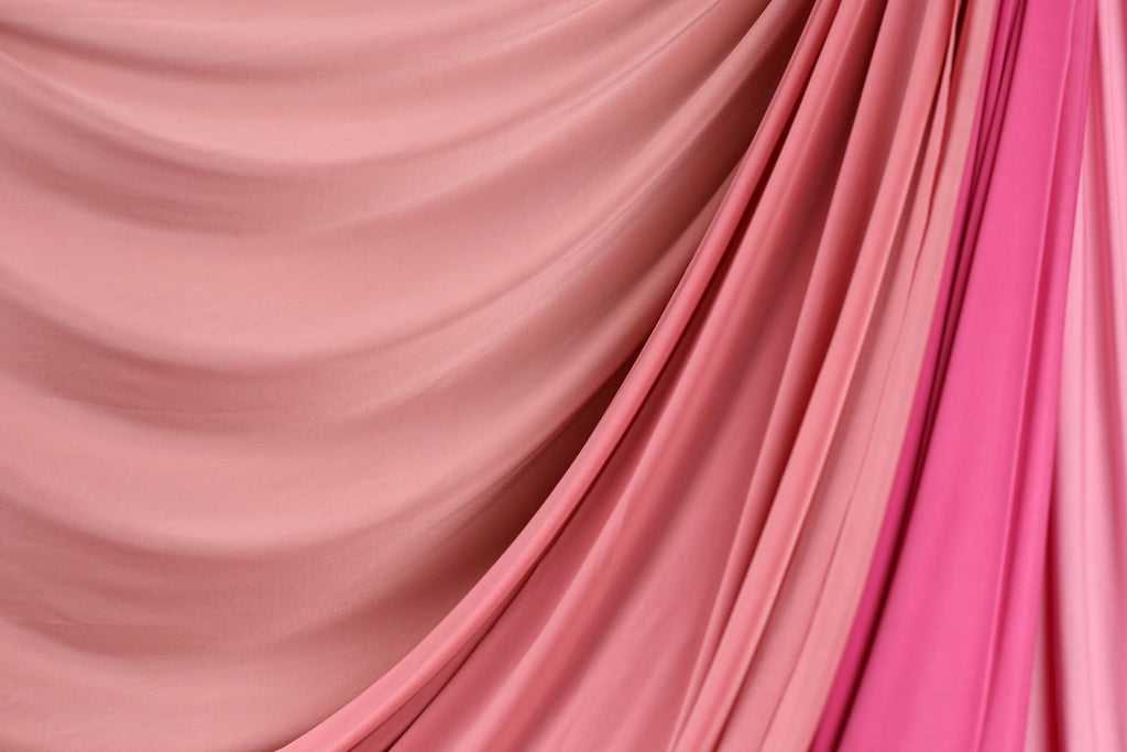 a close-up view of a fabric with a pink and red color gradient, creating a visually appealing and textured appearance.