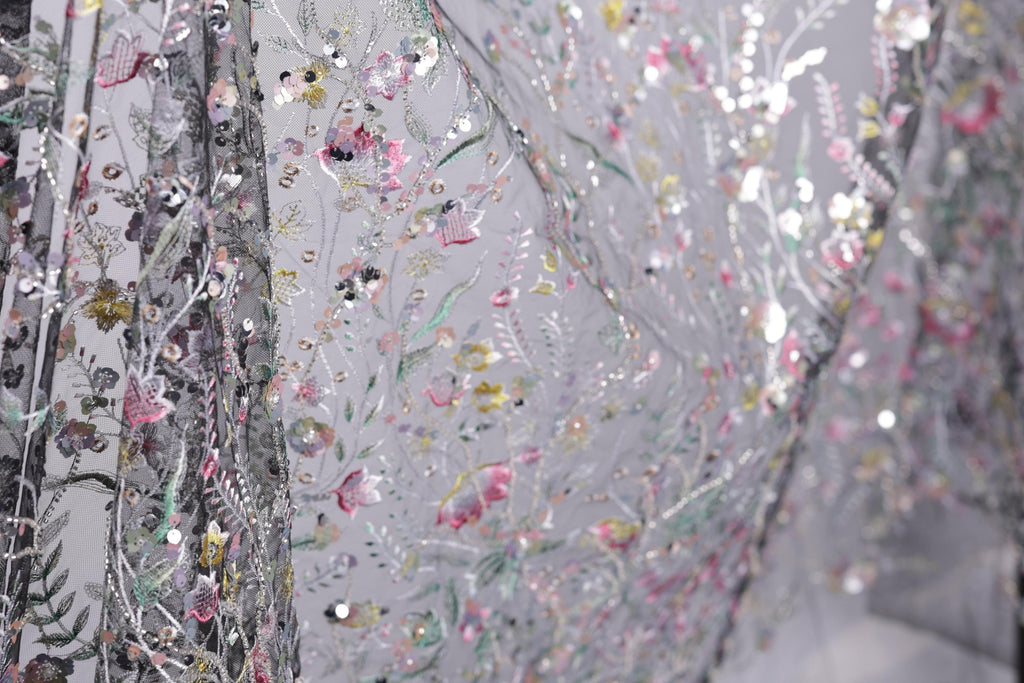 The image is a close-up view of a fabric with a floral pattern, featuring a variety of colors and textures.