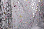 The image is a close-up view of a fabric with a floral pattern, featuring a variety of colors and textures.