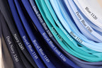 A collection of fabric swatches in various shades of blue, including navy, royal blue, turquoise, aqua, and light blue, with labels indicating the color names and numbers.