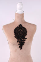 A mannequin head with a black lace design on the back.