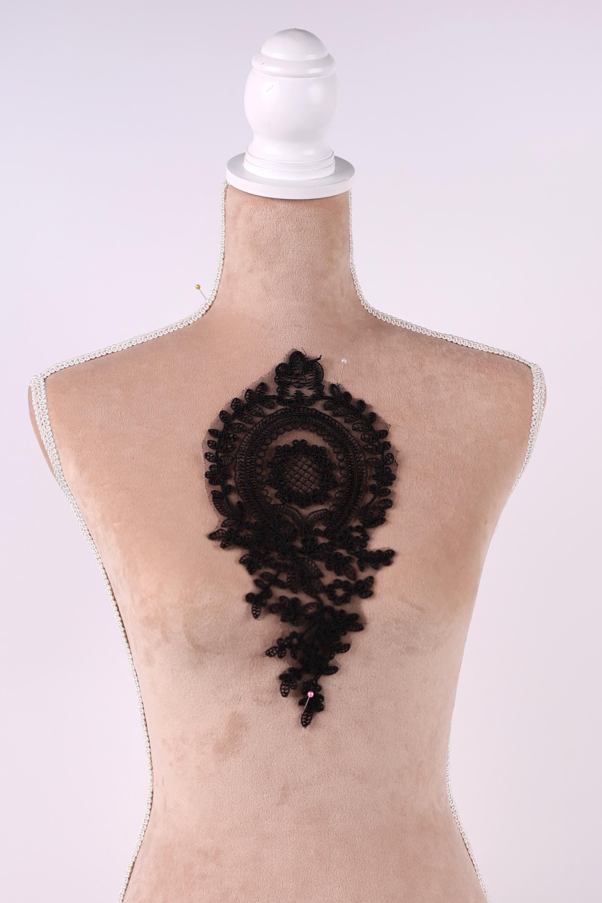 A mannequin head with a black lace design on the back.