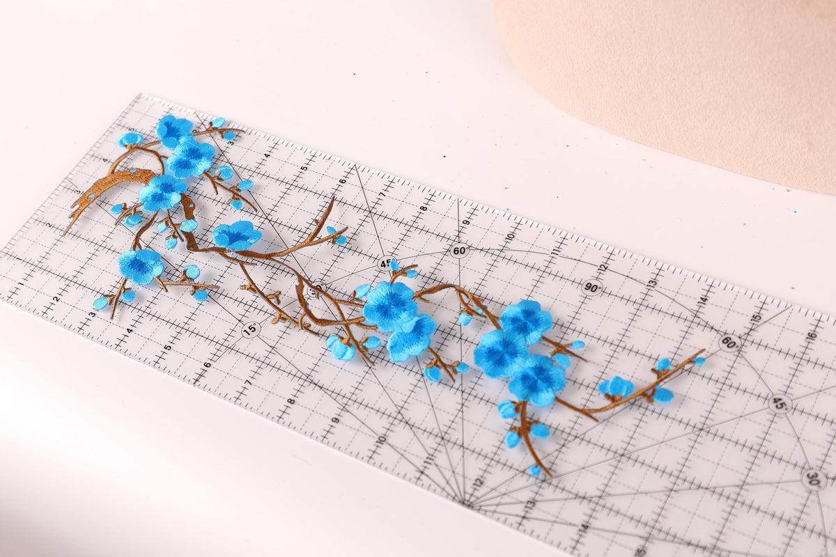 a close-up view of a clear ruler with blue flower petals attached to it, creating a decorative pattern.