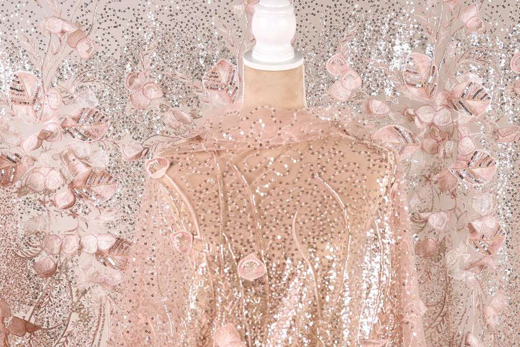 a pink sequin fabric with a floral pattern, displayed on a mannequin.