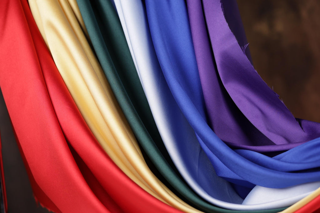 A close-up view of a colorful fabric with various shades of red, yellow, green, blue, and purple.