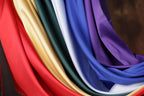 A close-up view of a colorful fabric with various shades of red, yellow, green, blue, and purple.