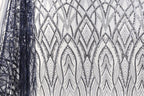 a close-up view of a fabric with a repeating pattern of black and white diamond shapes, creating an intricate and visually striking design.