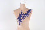 A mannequin with a beige body and a blue floral lace overlay on its chest.