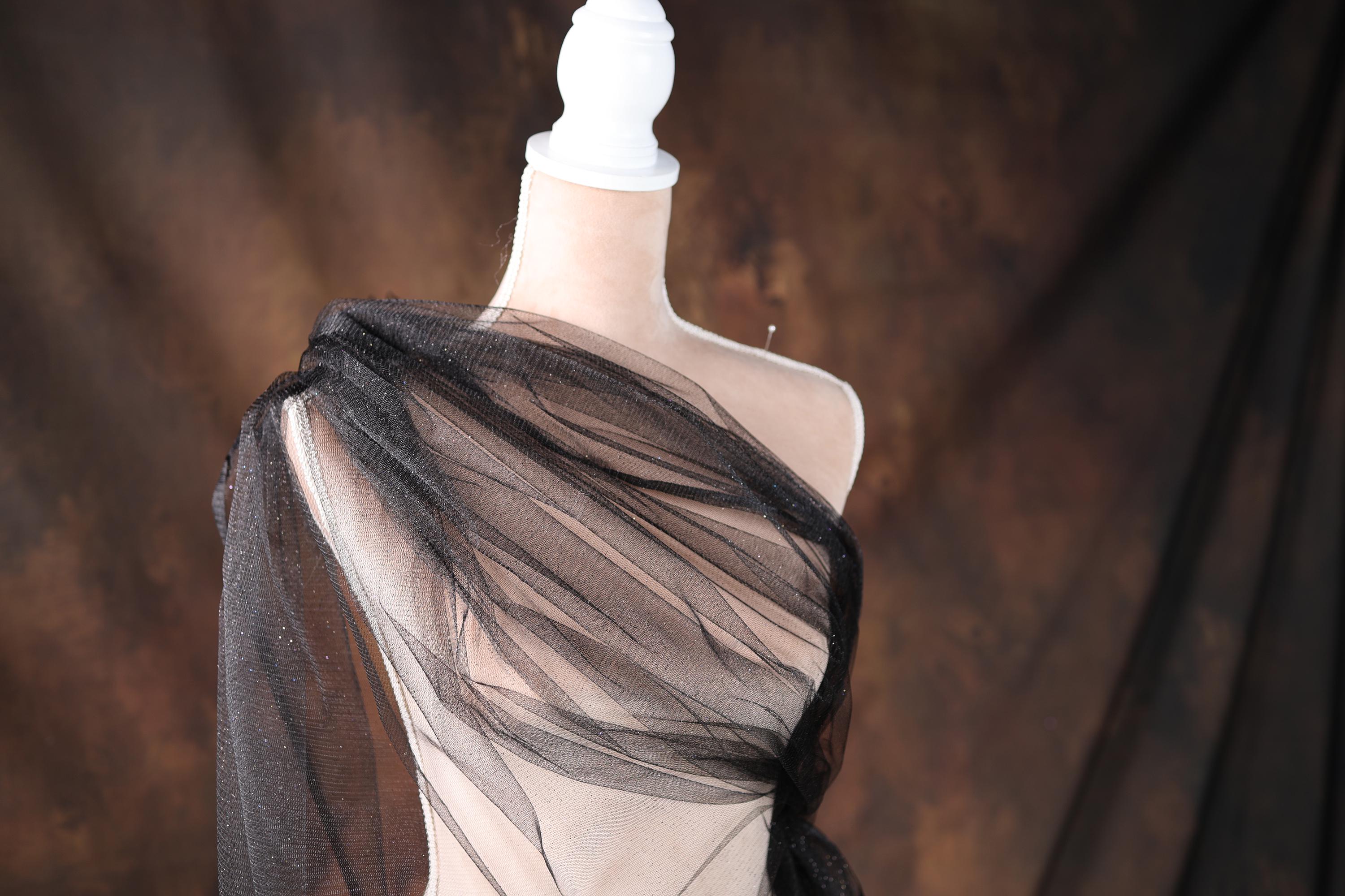a mannequin wearing a black dress with sheer fabric