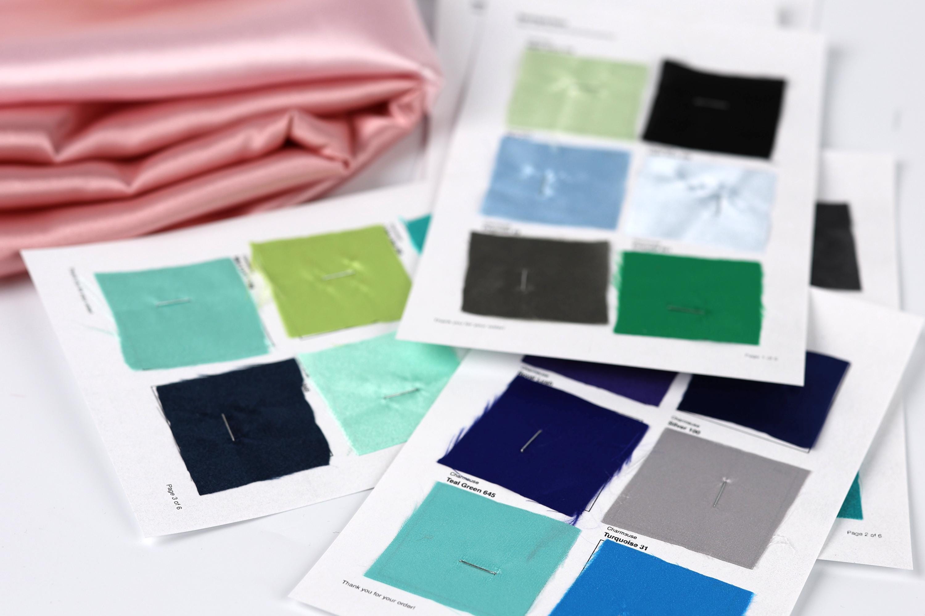 a collection of fabric swatches, each with a different color, laid out on a white surface.