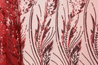 a close-up view of a fabric with a striking red and black sequin pattern. The pattern consists of various lines and shapes, creating a visually captivating design. The fabric appears to be a sheer material, allowing the intricate details of the sequin pattern to be clearly visible.