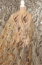 a mannequin wearing a sheer, gold-colored fabric with a floral pattern. The fabric appears to be made of sequin material and is draped over the mannequin's torso.