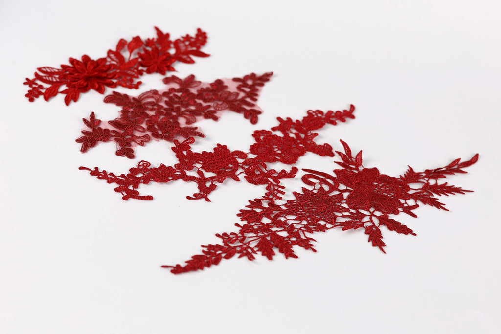 red floral embroidery pieces on a white background.