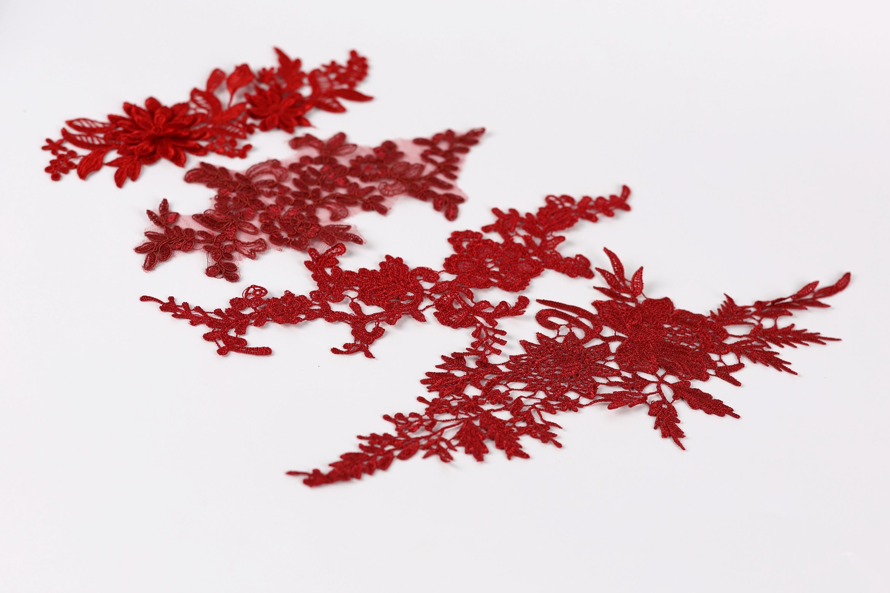 red floral embroidery pieces on a white background.