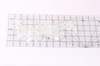 a clear ruler with a white lace pattern placed on it, indicating that it is being used for measuring or crafting purposes.