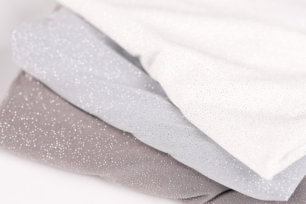 A close-up image of three fabric swatches, with the topmost one being white, the middle one being gray, and the bottom one being brown.
