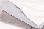 A close-up image of three fabric swatches, with the topmost one being white, the middle one being gray, and the bottom one being brown.