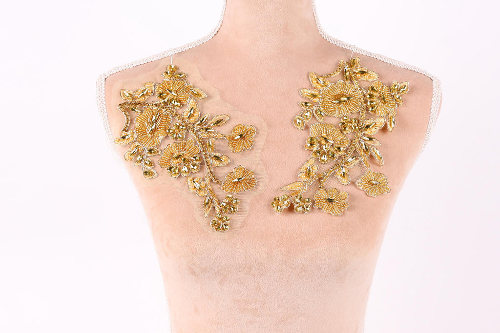 a mannequin with two gold floral patches on its bust area.