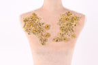a mannequin with two gold floral patches on its bust area.