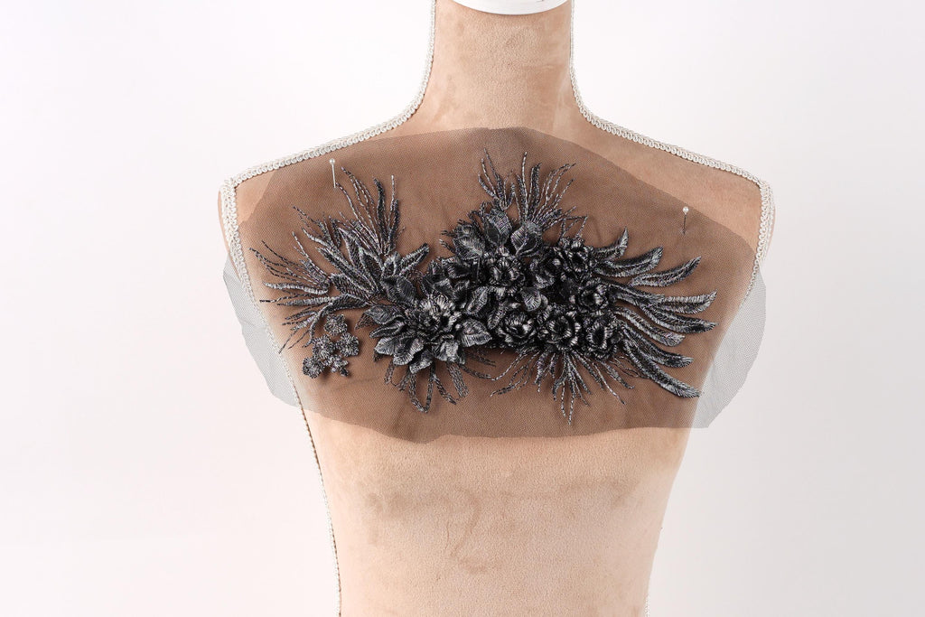 a mannequin with a decorative fabric piece on its back, featuring a floral design.