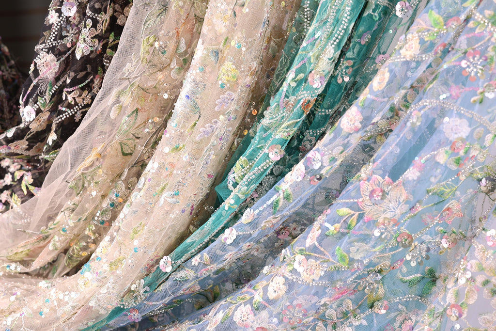 a variety of colorful, intricately embroidered fabric pieces, including a mix of floral and geometric patterns.