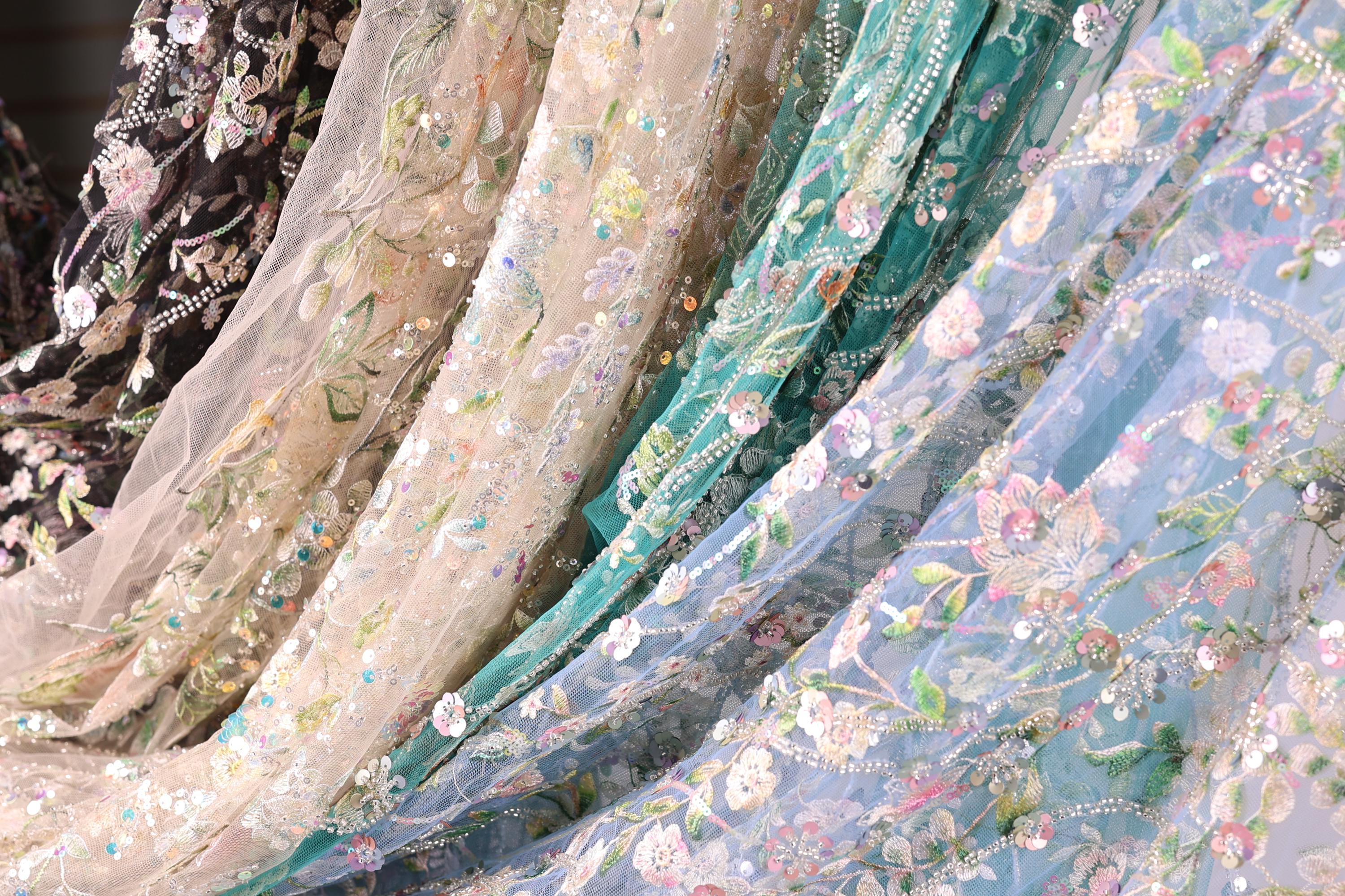 a variety of colorful, intricately embroidered fabric pieces, including a mix of floral and geometric patterns.
