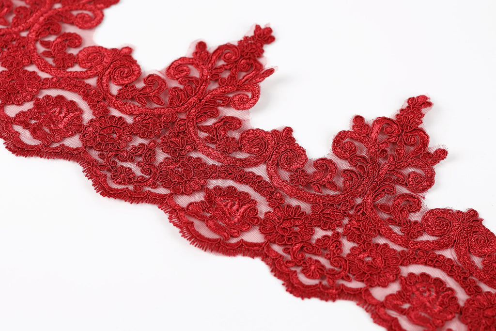 a close-up view of a red, intricately designed lace or embroidery piece.