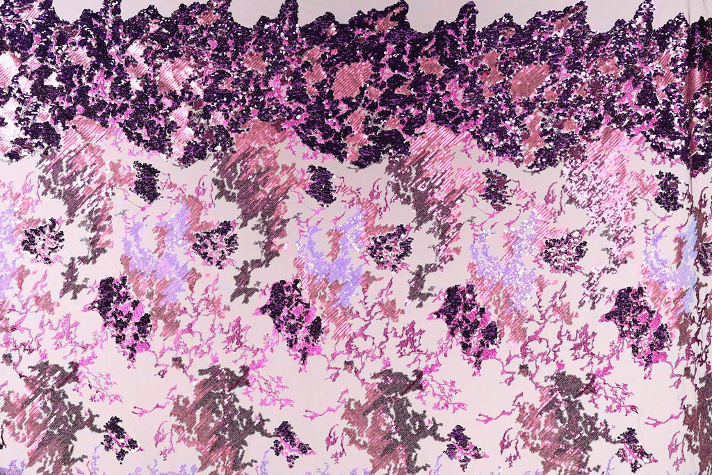 The image is a collage of various images, featuring a pattern of pink and purple sequins or sequin-like textures. The pattern is composed of different shapes and sizes of sequins, creating a visually striking and intricate design.