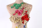 a mannequin with a variety of colorful floral embroidery on its back.