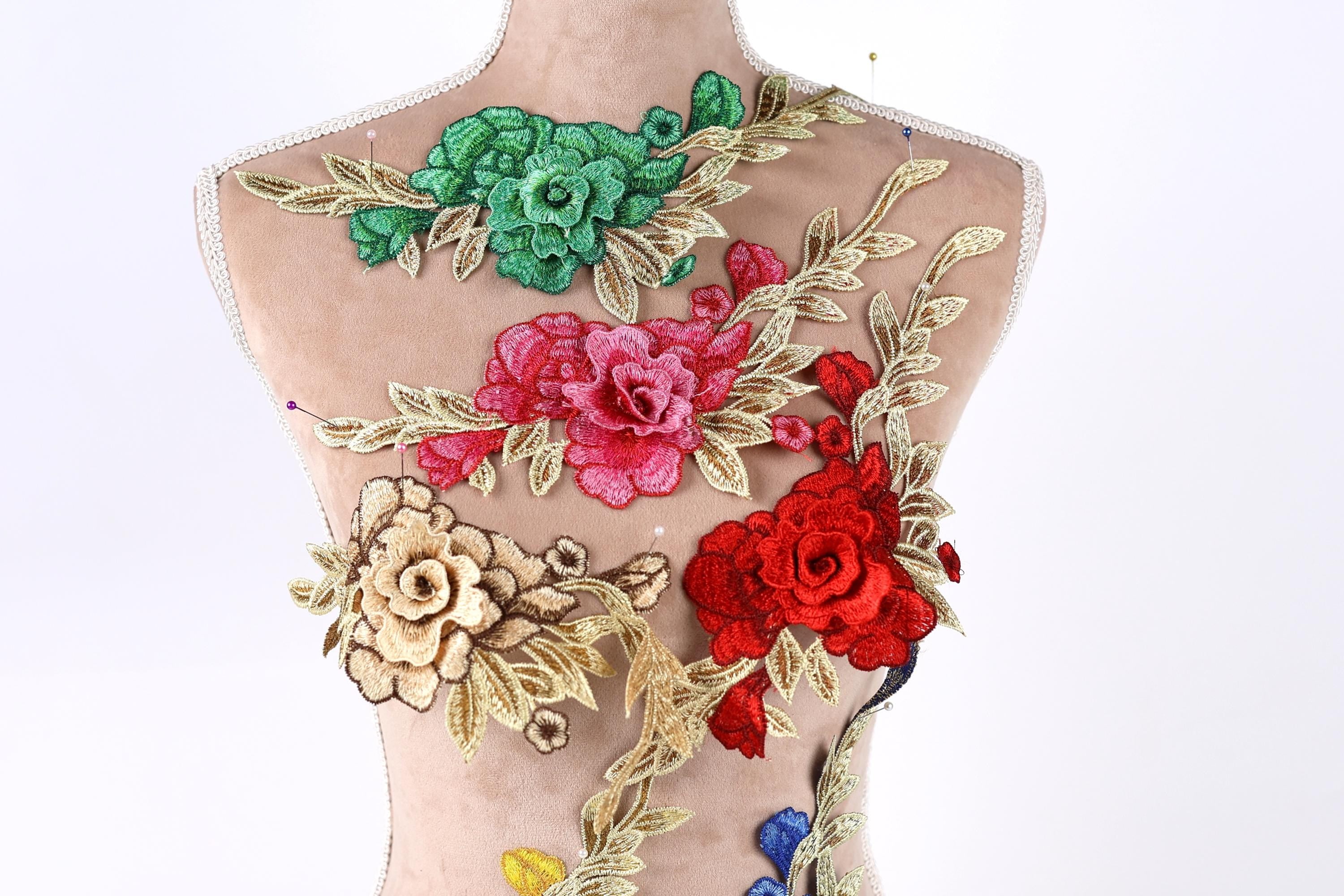 a mannequin with a variety of colorful floral embroidery on its back.