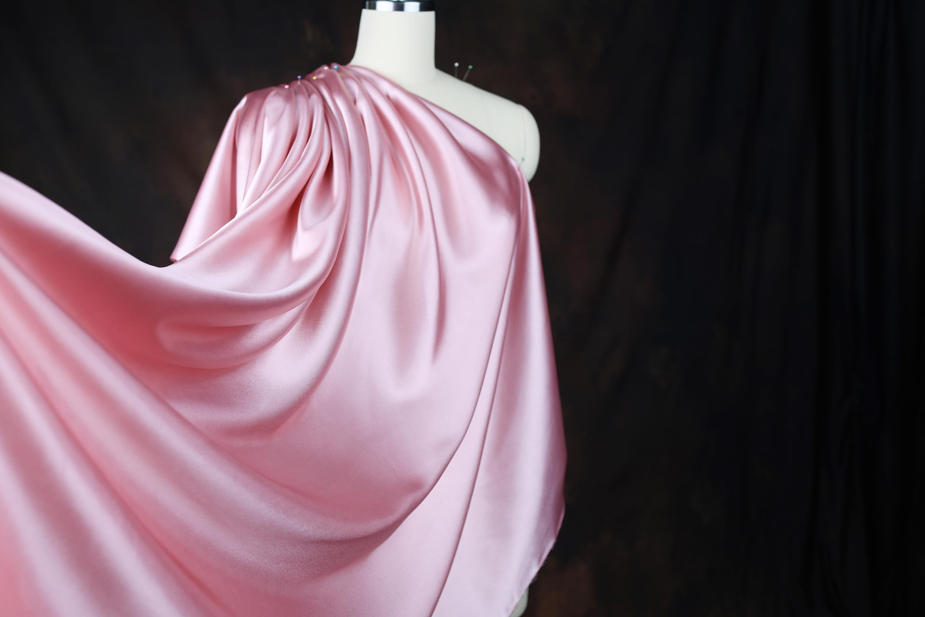 a mannequin wearing a pink draped dress