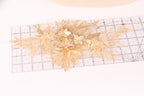 a close-up view of a decorative gold flower arrangement on a transparent ruler.