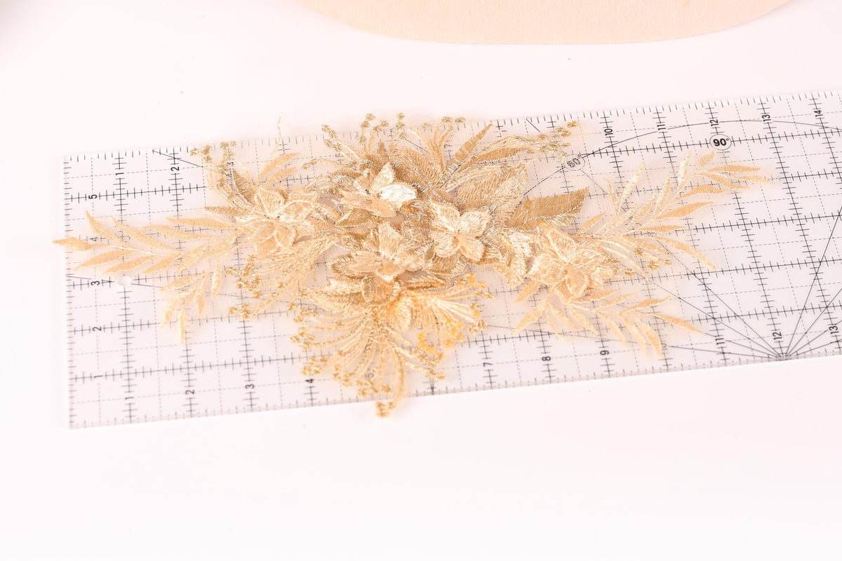 a close-up view of a decorative gold flower arrangement on a transparent ruler.